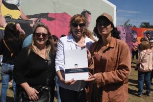 María Isabel Bosco, Presidenta Comunal de Elortondo, sostiene en sus manos la Declaratoria de Interés del Segundo Encuentro de Muralismo. Reconocimiento de la Cámara de Senadores y la Cámara de Diputados de Santa Fe.